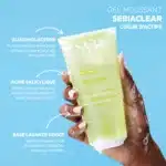 Une main tient un tube de SVR Sebiaclear Gel Moussant Nettoyant Anti-Imperfections Purifiant 200 ml sur un fond bleu avec un texte descriptif soulignant les bienfaits de ses ingrédients. dakar, Sénégal