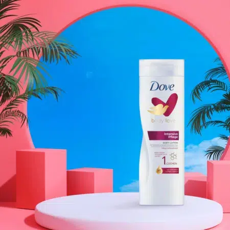 Un flacon de lotion pour le corps Dove Intensive Repair Lait de Corps 400 ml est posé élégamment sur un piédestal blanc, entouré de blocs roses, de feuilles de palmier et d'un ciel bleu en arrière-plan. dakar, Sénégal