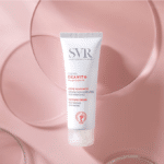 Tube de SVR Cicavit+ Crème Apaisante Réparation Accélérée Anti-Marques 40 ml sur fond rose à reflets circulaires, disponible chez Univers Cosmetix, Sénégal.