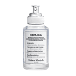 Flacon en verre transparent de Maison Margiela REPLICA Lazy Sunday Morning Eau de Toilette pour femme 30 ml avec vaporisateur argenté et étiquette blanche avec descriptions textuelles.