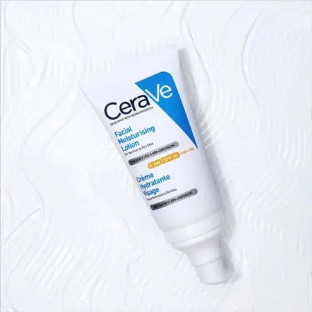CeraVe Crème hydratante visage SPF50 pour peaux normales à sèches dans un flacon de 52 ml sur fond blanc texturé.