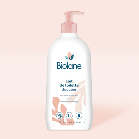 Un flacon de Biolane Lait de Toilette Douceur Visage, Corps 750 ml, connu pour sa qualité, avec une pompe rose sur fond rose clair, illustrant l'engagement d'Univers Cosmetix pour l'excellence à Dakar.