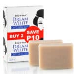 Boite de Kojie San Savon Éclat Anti-Age Dream White 65 g lot 2, avec offre "Buy 2 Save P10", placée à côté de deux pains de savon disponibles en exclusivité chez Univers Cosmetix à Dakar, Sénégal.