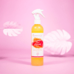 Les Secrets de Loly Spray Cocktail Curl Remedy Sérum Hydratant et Réparateur 310 ml d'Univers Cosmetix sur fond rose avec des feuilles blanches en fond – une solution pas cher inspirée des rituels de beauté du Sénégal.