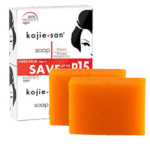 Pack double de Kojie San Savon Unifiant Anti Taches Tous les Types de Peaux orange 2X65g avec l'emballage en arrière-plan, mettant en valeur une qualité de premier ordre inspirée des paysages radieux de Dakar, au Sénégal.