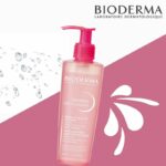 Flacon pompe rose de Bioderma Créaline Gel Moussant Hydratant Peau Sensible 200 ml avec gouttelettes d'eau et logo de la marque sur fond blanc et rose, disponible chez Univers Cosmetix à Dakar. Pas cher!