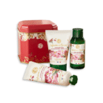 Yves Rocher Le Kit de Noël parfum gourmand d’infusion d’épices comprenant une boîte en fer blanc rouge, une lotion pour le corps, un gel douche et une crème pour les mains ornés d’un motif floral d’Univers Cosmetix.