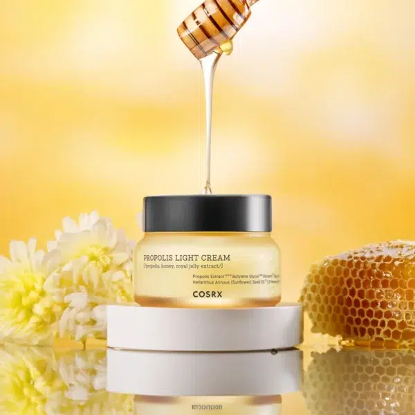 Cosrx Crème Hydratante Légère à la Propolis d'Abeille Noire Anti Imperfections 65 ml dans un pot avec du miel ruisselant d'une louche au-dessus, entouré de fleurs et d'un nid d'abeilles. dakar, Sénégal