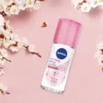 Nivea Brightening Deep Sakura + Vitamin C Serum Deodorant Éclaircissant Aisselles (40 ml) sur un fond rose avec des fleurs de cerisier entourant le flacon. dakar, Sénégal