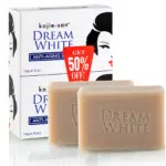 Deux barres de savon Kojie San Savon Éclat Anti Age Dream White sont présentées devant leur emballage étiqueté « Kojie San Savon Éclat Anti Age Dream White 2 x 135 g », avec une étiquette de réduction de 50 %. dakar, Sénégal