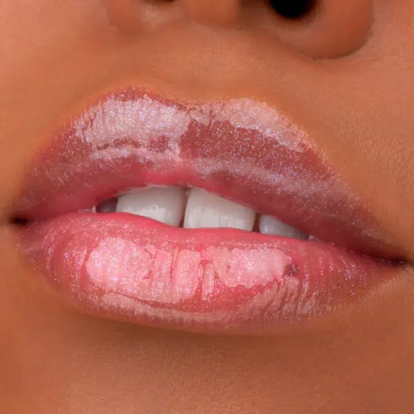 Gros plan sur des lèvres brillantes et chatoyantes d'une teinte rose naturelle, rehaussées par le brillant à lèvres Juicy Bomb Shiny Lipgloss 105 Bouncy Bubblegum 10 ml d'Essence Cosmetics. Les dents sont légèrement visibles derrière les lèvres.