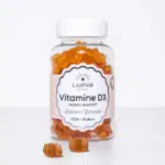 Un flacon de gummies LASHILE BEAUTY Vitamine D3 Fonctionnement du système immunitaire avec des oursons en gélatine orange à l'intérieur, étiquetés « Vegan | 60 pièces », conçus pour soutenir le système immunitaire.