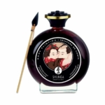 Un flacon rond de Shunga Peinture de Corps Comestible Chocolat Aphrodisiaque 100 ml avec une étiquette d'art japonais, accompagné d'un pinceau, et rehaussé du parfum exotique de Toko Aroma Fruits exotiques.