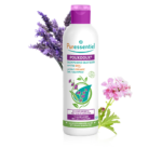 Un flacon de Puressentiel Shampoing Quotidien certifié BIO Pouxdoux® 200 ml au bouchon violet, entouré de fleurs fraîches de lavande et de roses. dakar, Sénégal