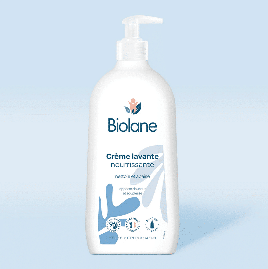 Biolane Crème Lavante Bébé Corps et Cheveux Blanc Flacon de 750 ml avec bouchon pompe sur fond bleu clair. Le texte en français sur l'étiquette signifie sa haute qualité