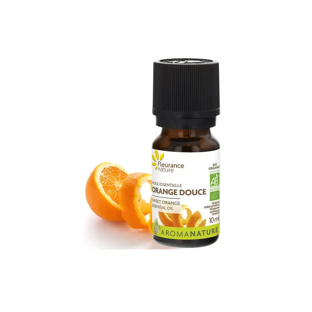 Flacon d'huile essentielle étiqueté "Fleurance Nature Huile essentielle d'Orange douce Bio 10 ml" à côté d'orange tranchée sur un fond blanc pur