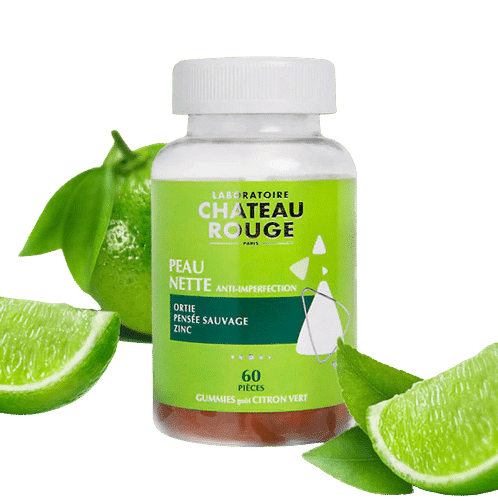 Une bouteille de Chateau Rouge Gummies Peau Nette Anti-imperfections 60 gummies avec des tranches de citron vert et un citron vert entier en arrière-plan