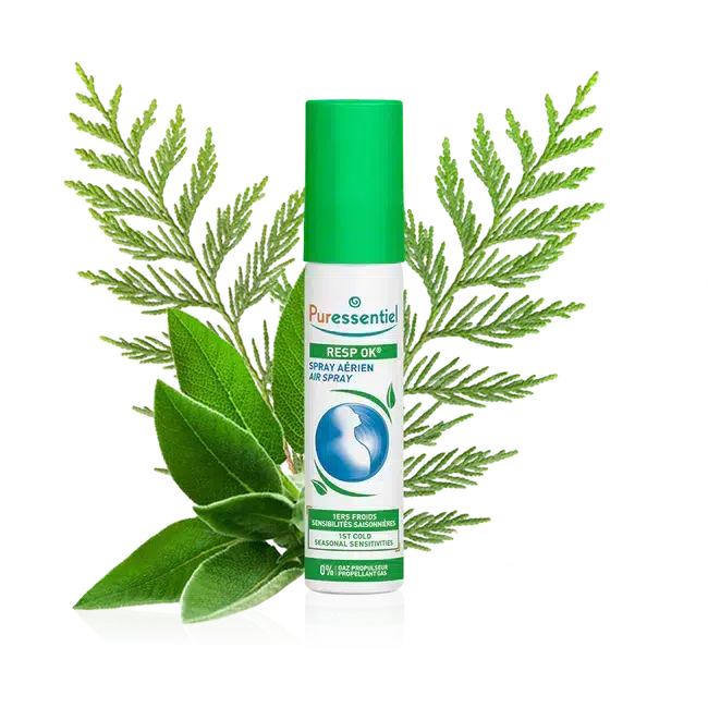 Un flacon de PURESSENTIEL Spray Aérien Resp'OK 20 ml avec en arrière plan un feuillage vert et des herbes.