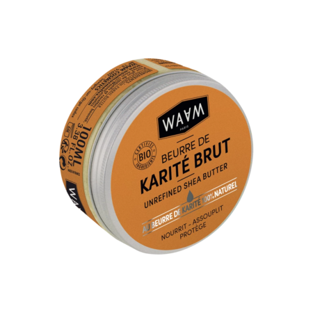 Une boîte ronde de beurre de karité non raffiné de marque WAAM avec une étiquette orange et un texte noir et blanc. L'étiquette met en avant la certification biologique et les propriétés nourrissantes, adoucissantes et protectrices. Le couvercle est légèrement ouvert, laissant apparaître une substance blanche. Dakar