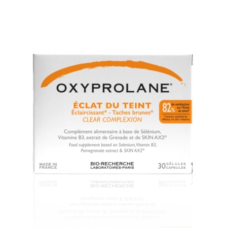 La boîte blanche d'Oxyprolane Éclat du Teint Anti Taches Éclaircissant, avec texte en français et en anglais, contient 30 gélules enrichies en sélénium, vitamine B3 et extrait de grenade. Fabriqué en France par Bio-Recherche Laboratoires-Paris, il complète le collagène Biocyte pour une peau éclatante. Dakar