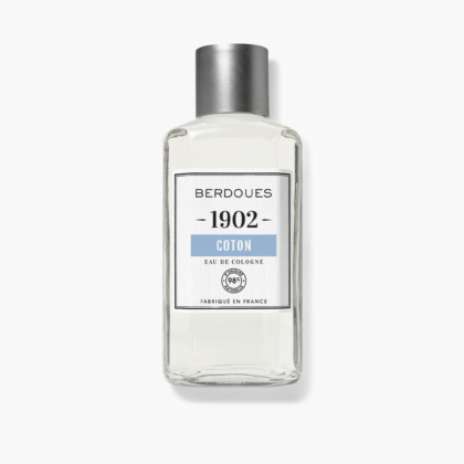Flacon en verre transparent d'Eau de Cologne Berdoues 1902 Coton avec bouchon argenté. L'étiquette porte le nom de la marque, le nom du produit et la mention « Fabriqué en France ». Le liquide à l'intérieur est transparent. Dakar