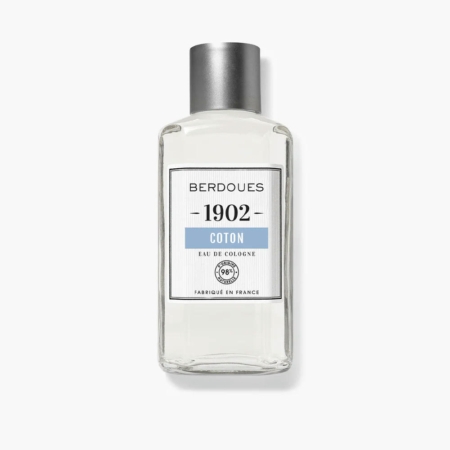 Flacon en verre transparent d'Eau de Cologne Berdoues 1902 Coton avec bouchon argenté. L'étiquette porte le nom de la marque, le nom du produit et la mention « Fabriqué en France ». Le liquide à l'intérieur est transparent. Dakar