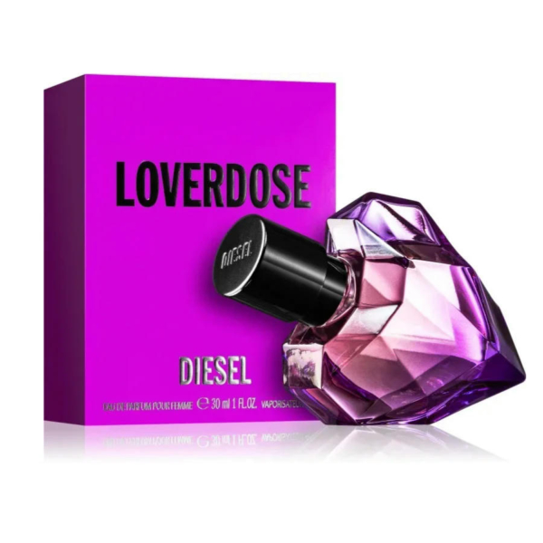 L'image montre un flacon de parfum Loverdose de Diesel, en forme de cœur facetté en verre violet. Il est placé à côté de son emballage violet vif, sur lequel figure le nom de la marque en lettres noires et épaisses. Dakar