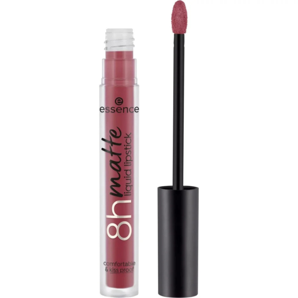 Un tube de rouge à lèvres liquide mat Essence 8h, d'une teinte rouge rosé, sans le bouchon. L'applicateur repose à côté, laissant apparaître un embout éponge enduit de la même couleur. L'inscription sur le tube indique « confortable et résistant aux baisers ». Dakar