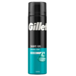 Une bombe de gel à raser Gillette avec un bouchon noir. L'étiquette comporte les inscriptions « GEL À RASER » et « PARFUM ORIGINAL », avec la mention « SENSITIVE » surlignée. La partie bleu sarcelle présente un tourbillon de gel et indique qu'il est parfumé. Dakar