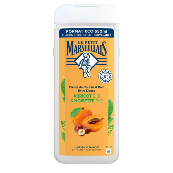 Flacon blanc de crème douche « Le Petit Marseillais », orné d'une étiquette aux motifs d'abricot et de noisette. L'étiquette porte l'inscription « Abricot Bio & Noisette Bio ». Le flacon, d'une contenance de 650 ml, arbore des symboles écologiques et recyclables. Dakar