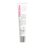 Tube blanc de crème de nuit Topicrem MELA avec une étiquette rouge et noire. Les inscriptions « Crème de nuit peeling doux anti-taches » et « Corrige et prévient » sont en anglais et en français, avec une image d'une goutte près du haut. Dakar